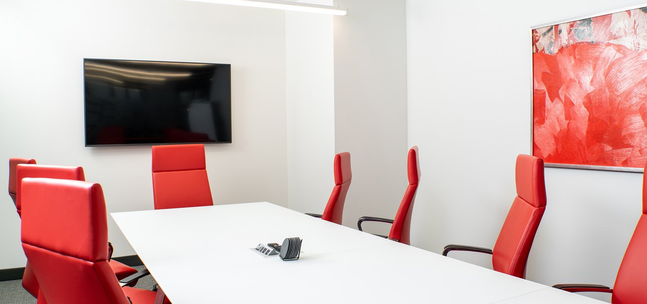 White and red shaded meeting room with a widescreen TV for video chat