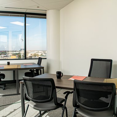 A fully equipped workstation with a city view in the back