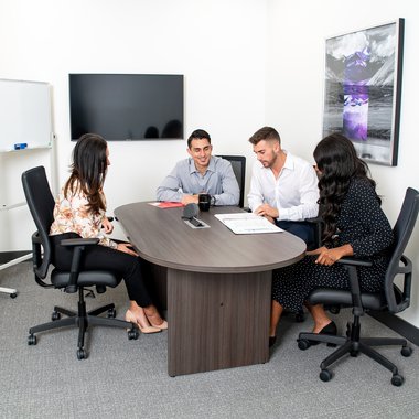 Professionals engaged in a conversation around a conference table
