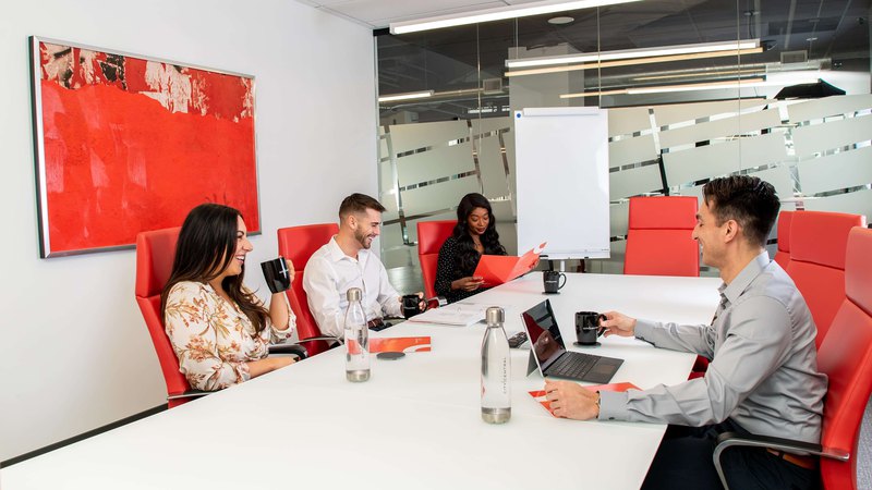 A meeting in progress in a white and red meeting room rental space in City Central