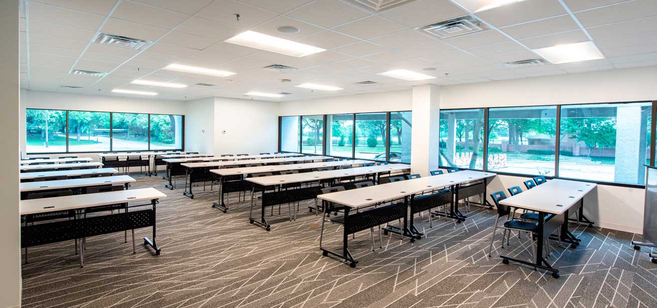 Meeting room with white tables and black chairs
