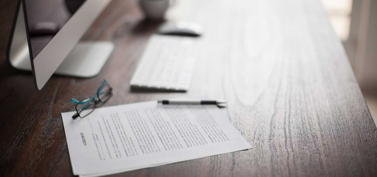 Leasing an office agreement on a table with a pen and glasses on it.